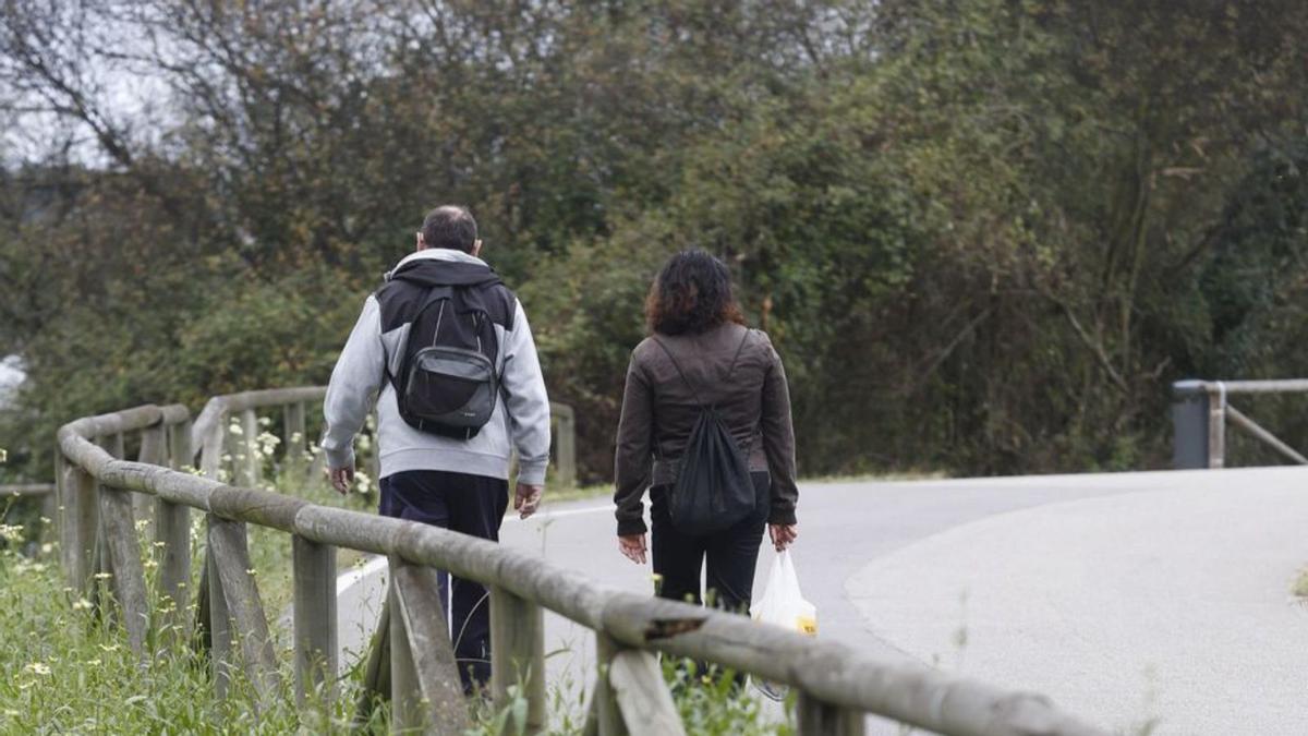 Paseantes por la senda peatonal del embalse de Trasona.