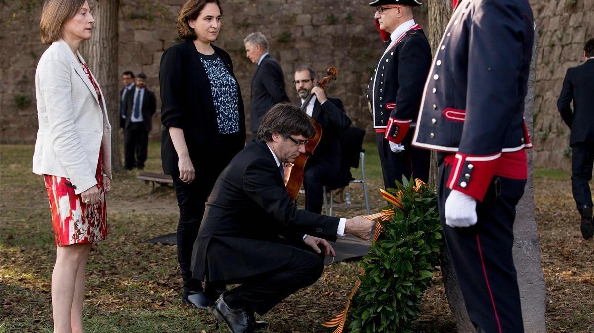 El presidente de la Generalitat  Carles Puigdemont junto a la alcaldesa Ada Colau y la presidenta del Parlament, Carme Forcadell, durante la tradicional ofrenda ante la tumba del presidente de la Generalitat republicana Lluis Companys coincidiendo con el 77 aniversario de su muerte  