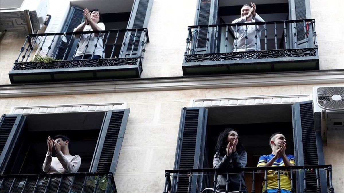 Vecinos del barrio de Lavapiés, en Madrid, aplauden a los sanitarios desde sus balcones