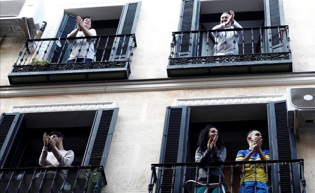 Vecinos del barrio de Lavapiés, en Madrid, aplauden a los sanitarios desde sus balcones.