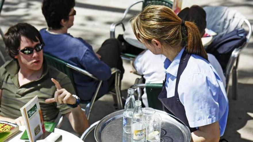 Camarera sirviendo a un cliente en una terraza de Palma.