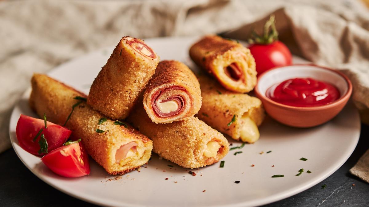 Rollitos de pan de molde con jamón y queso.