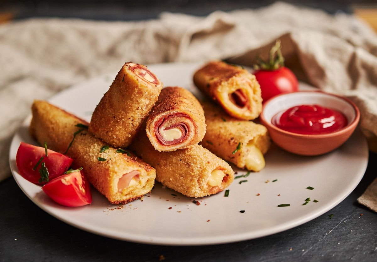 Rollitos de pan de molde con jamón y queso.