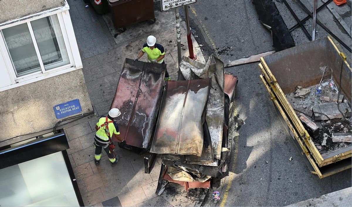 Los operarios estiran en el suelo las planchas retiradas por la grúa.