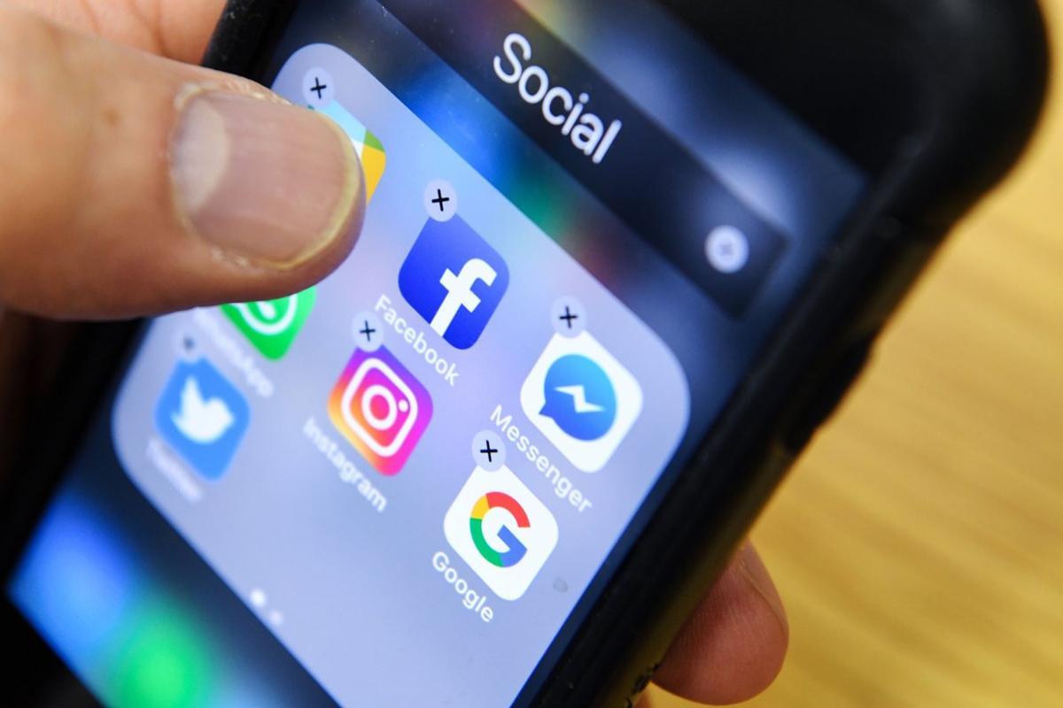 Una persona borra aplicaciones de redes sociales de su iPhone.