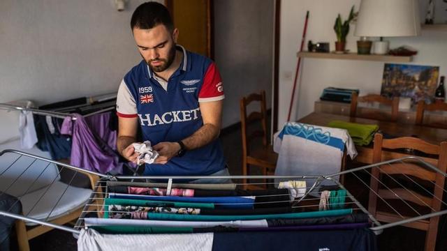 Un hombre tiende la colada, en su casa de Barcelona.