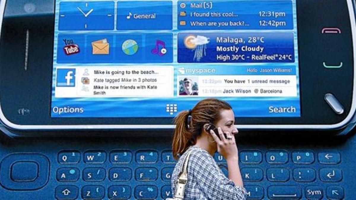 Una ciudadana londinense pasa ante un anuncio de un teléfono inteligente de Nokia.
