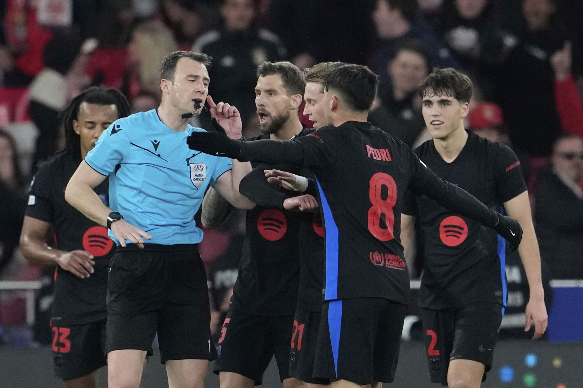 Barcelona players argue with referee Felix Zwayer after he shows a red card to Barcelona's Pau Cubarsi, right, during the Champions League round of 16 first leg soccer match between SL Benfica and FC Barcelona at the Luz stadium in Lisbon, Wednesday, March 5, 2025. (AP Photo/Armando Franca). EDITORIAL USE ONLY / ONLY ITALY AND SPAIN