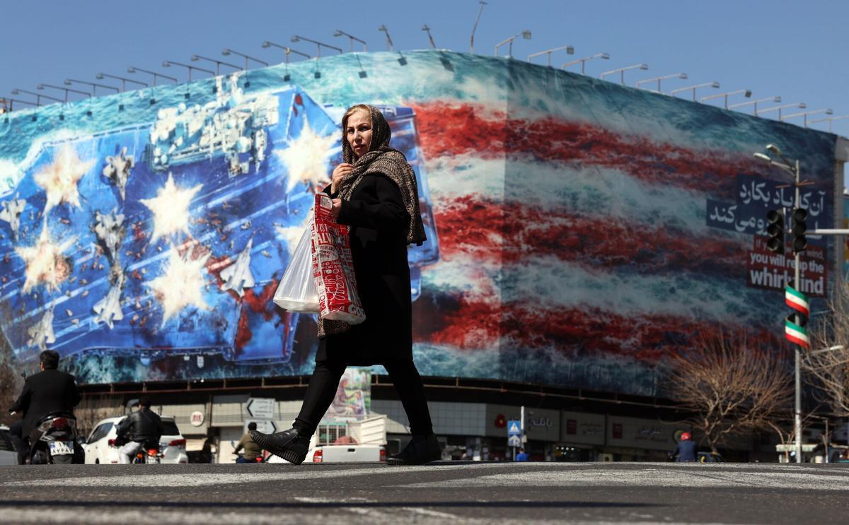 Una mujer iraní pasa frente a un mural antiEEUU en Teherán el 26 de febrero, dos días antes del ataque.