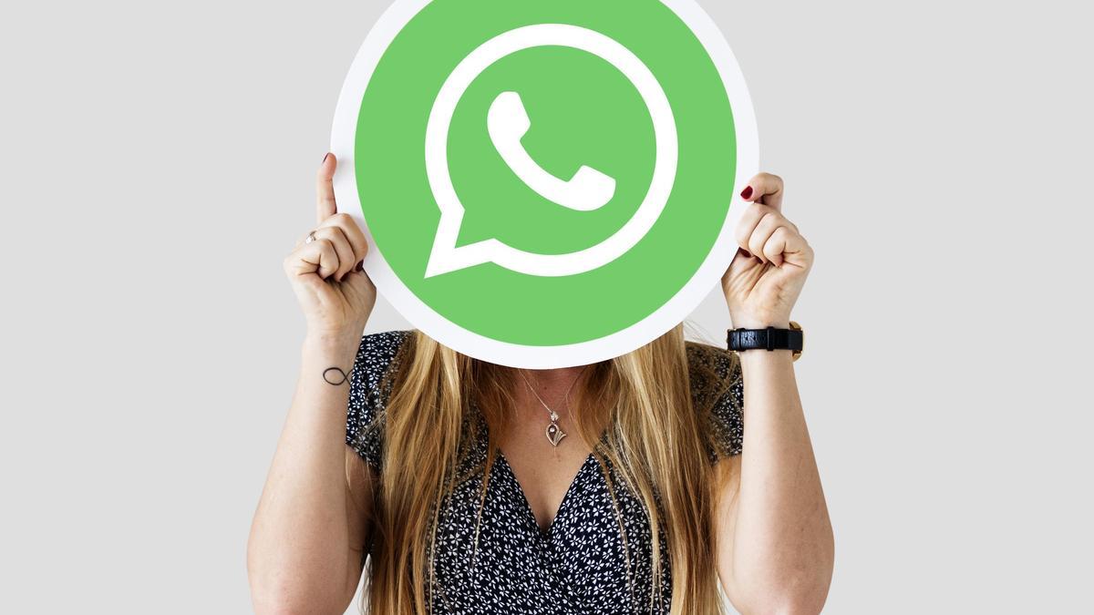 Una mujer se tapa el rostro con el icono de WhatsApp