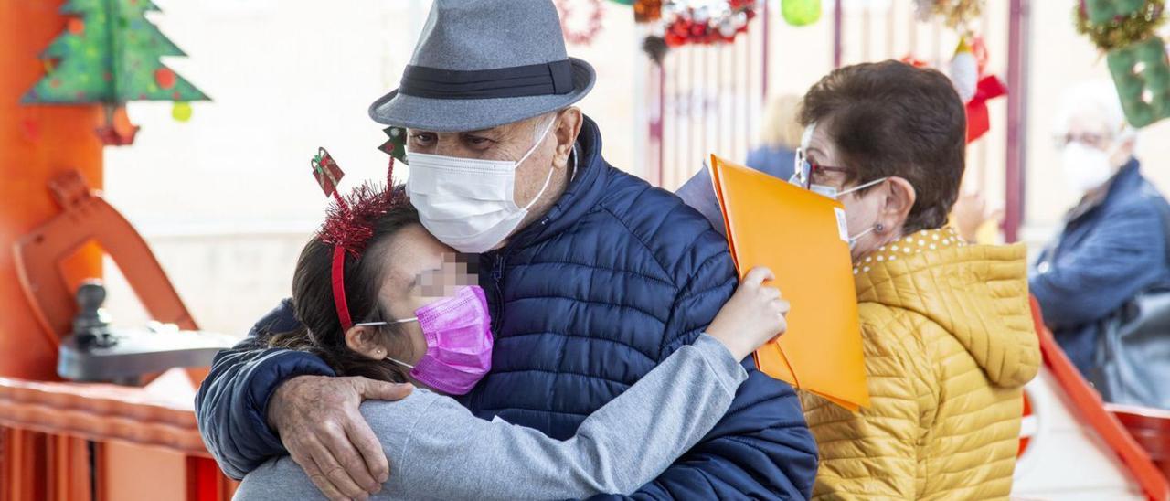 Un abuelo abraza a su nieta