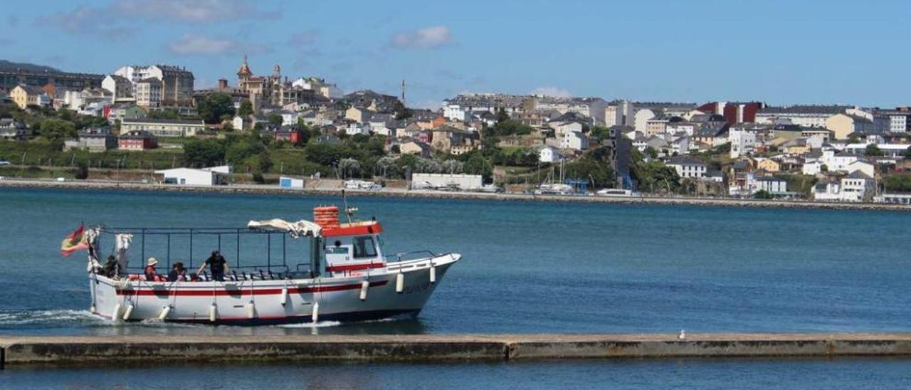 Una embarcación turística navegando ayer frente a Figueras, con Ribadeo al fondo.