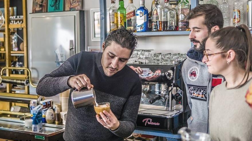 El barista palaciego Quique Ramírez sirve café a una pareja de clientes. / Á.R.