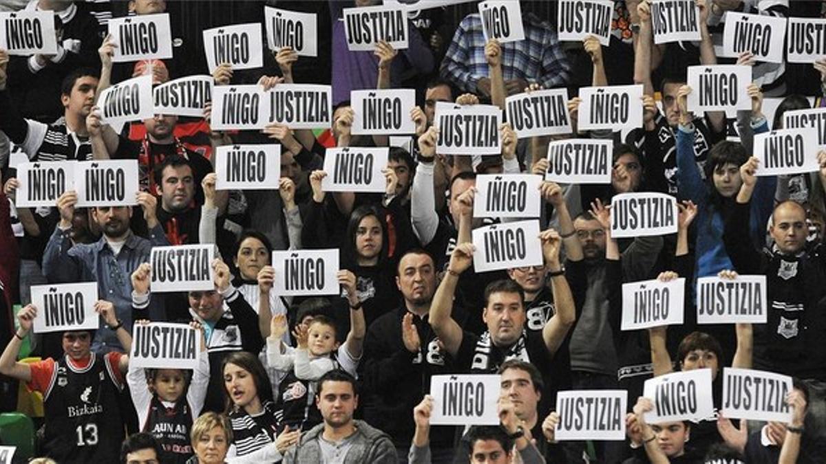 Asistentes a un partido de baloncesto muestran carteles pidiendo justicia por la muerte de Iñigo Cabacas.