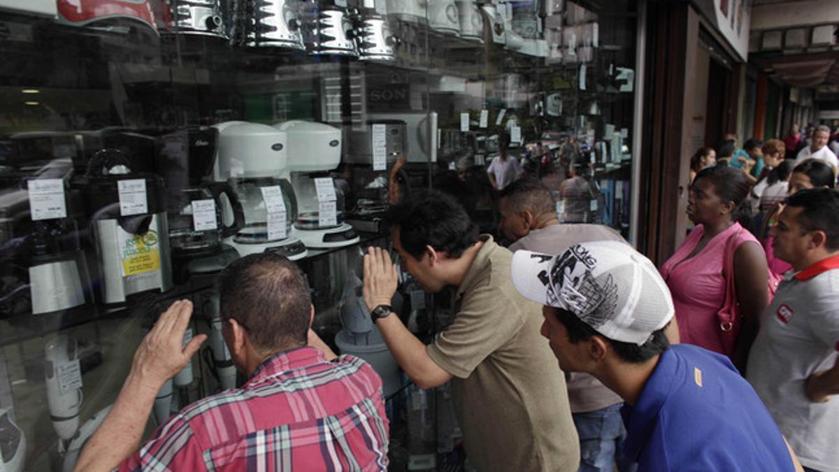 Venezolanos hacen cola ante una tienda de electrodomésticos, en Caracas.