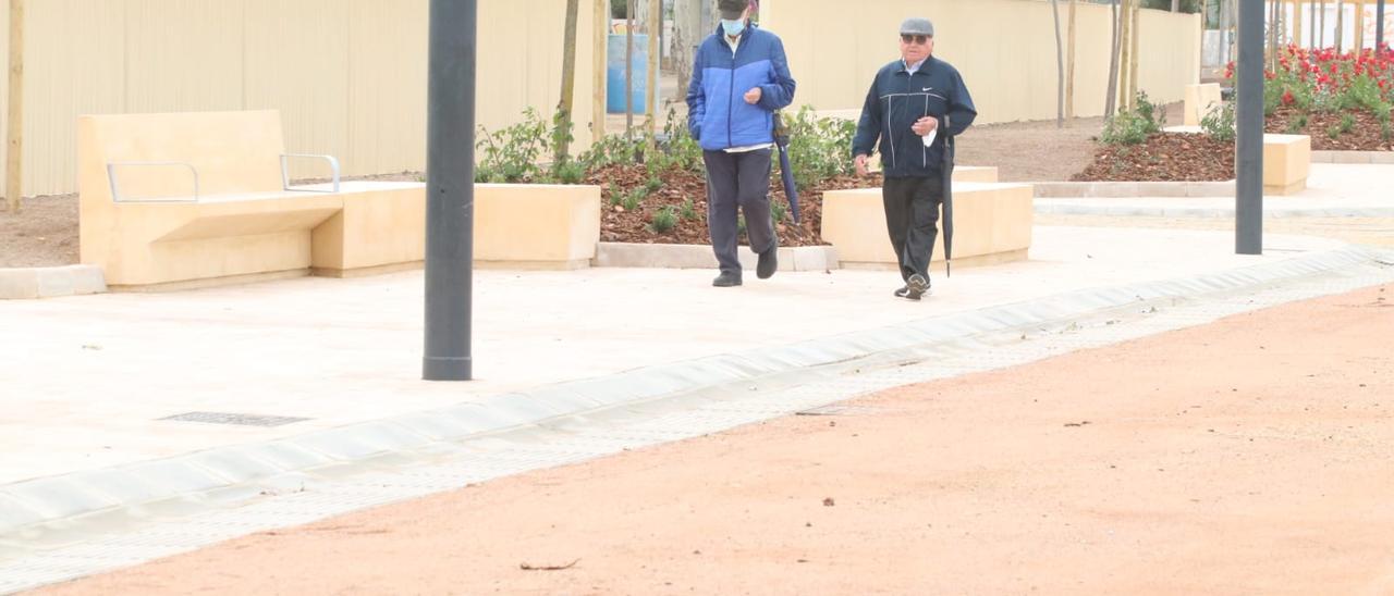 Dos hombres pasean por la reforma calle del Potro del recinto ferial de El Arenal.