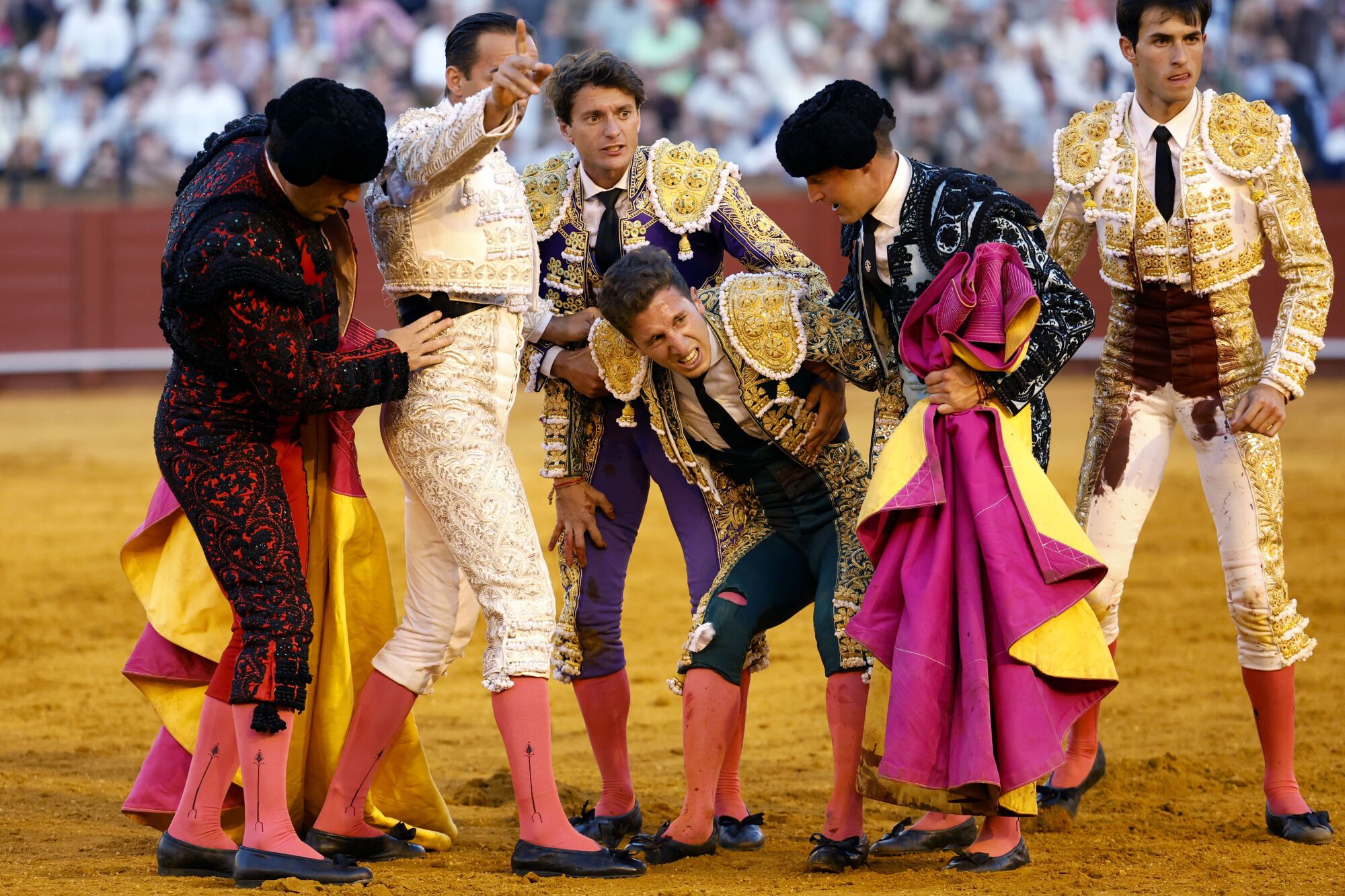 SEVILLA , 27/04/2025.- El diestro Juan Pedro García "Calerito" (3d) asistido por su cuadrilla tras ser volteado por el segundo de sus astados durante la corrida de la Feria de Abril celebrada este domingo en la plaza de toros de la Maestranza, en Sevilla. EFE/ Julio Muñoz
