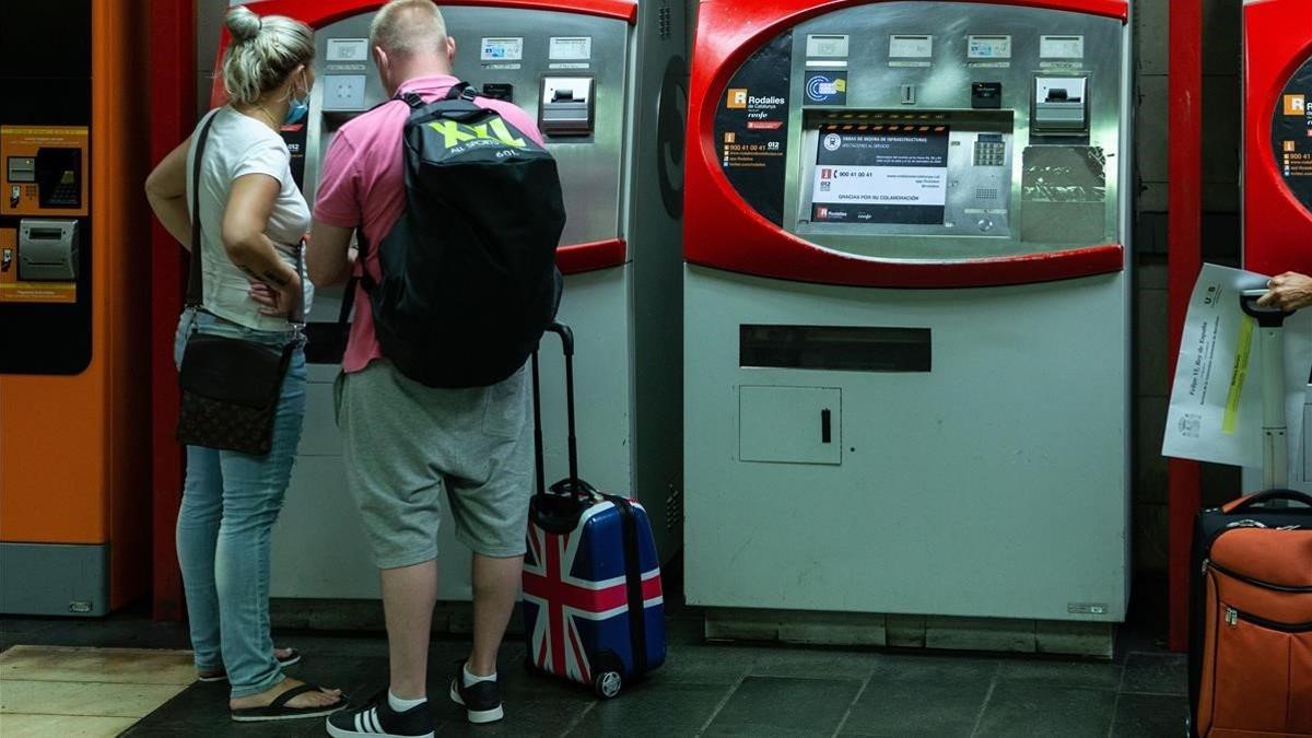 Una pareja de turistas británicos en la estacion de Renfe de Plaza Catalunya en Barcelona el 27 de julio del 2020