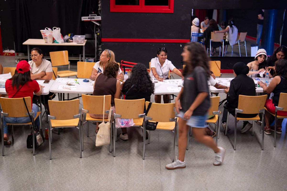 Un grupo de mujeres de entre 20 y 80 años, vecinas del barrio de la Trinitat Vella y usuarias del Centre de Vida Comunitària, participan en un taller de henna dentro de un casal de verano femenino.