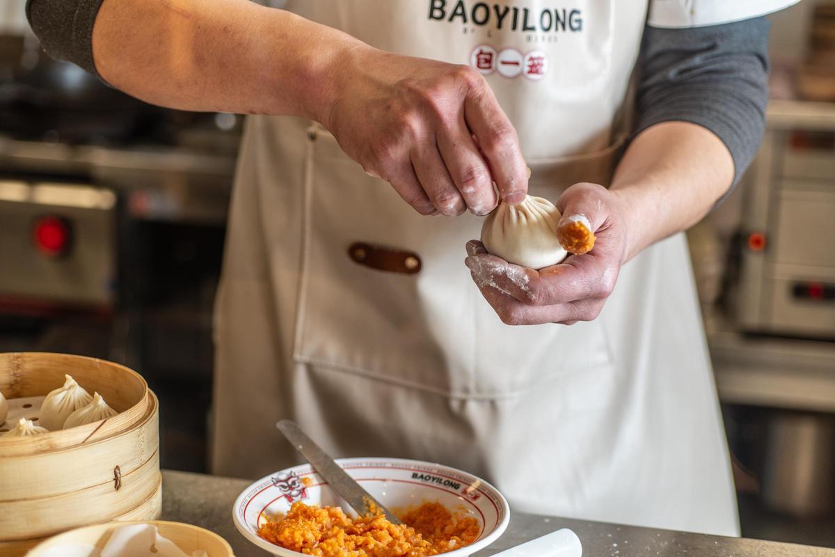El bao gigante de Baoyilong, relleno de caldo y huevas de cangrejo, se disfruta primero sorbiéndolo con pajita.