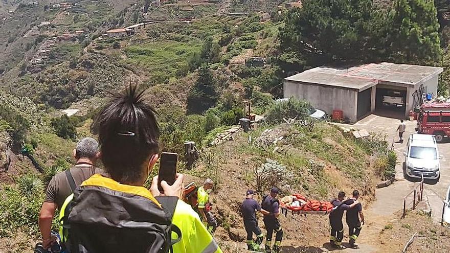 Los bomberos trasladan en camilla a una vecina de Los Toscales (Roque Negro) por un sendero de tierra de un kilómetros hasta una ambulancia.