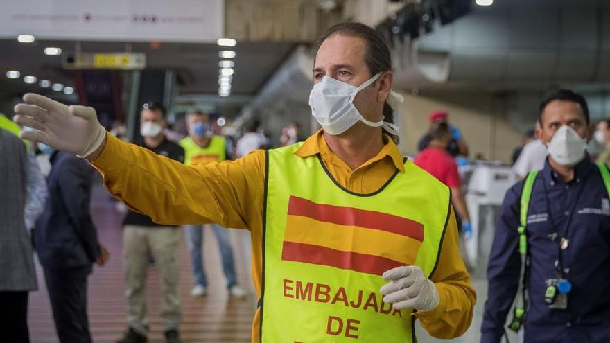 Un funcionario de la Emabajda de España en Venezuela guía a los ciudadanos europeos que tomarán un vuelo hacia Madrid.