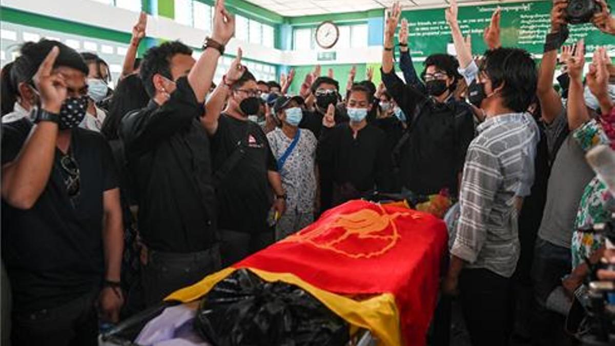 La gente muestra un saludo con tres dedosen el funeral de un estudiante de medicina de 19 años que fue abatido durante la represión contra los manifestantes.