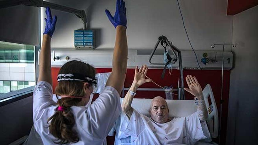 Una enfermera haciendo ejercicios de rehabilitación con un paciente que superó la covid-19.