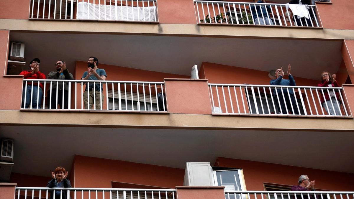 Vecinos de L'Hospitalet de Llobregat salen a sus balcones y ventanas a aplaudir a los sanitarios, el pasado 29 de marzo