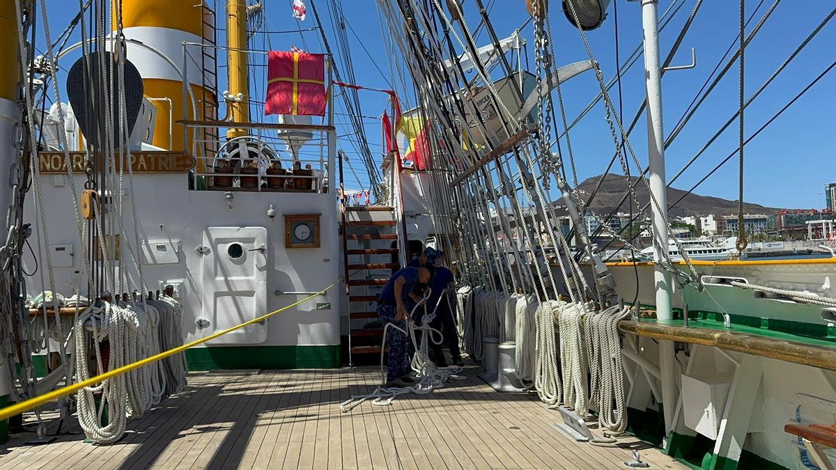 Marineros del 'Mircea' atan las jarcias y otros cabos del buque escuela.