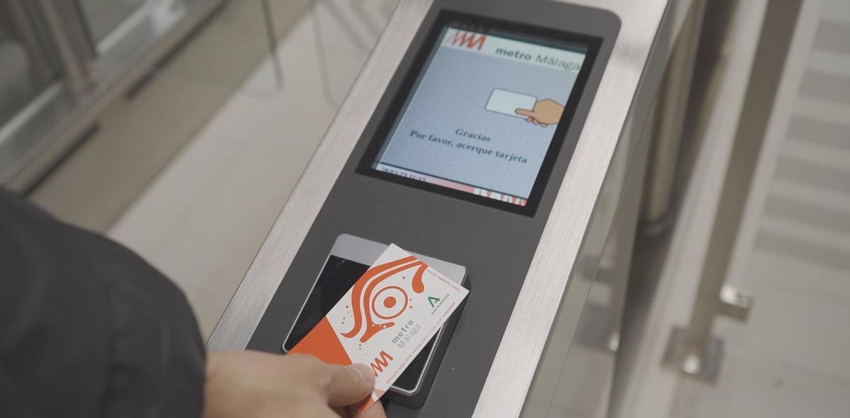 Persona pasando el billete en uno de los tornos del Metro de Málaga