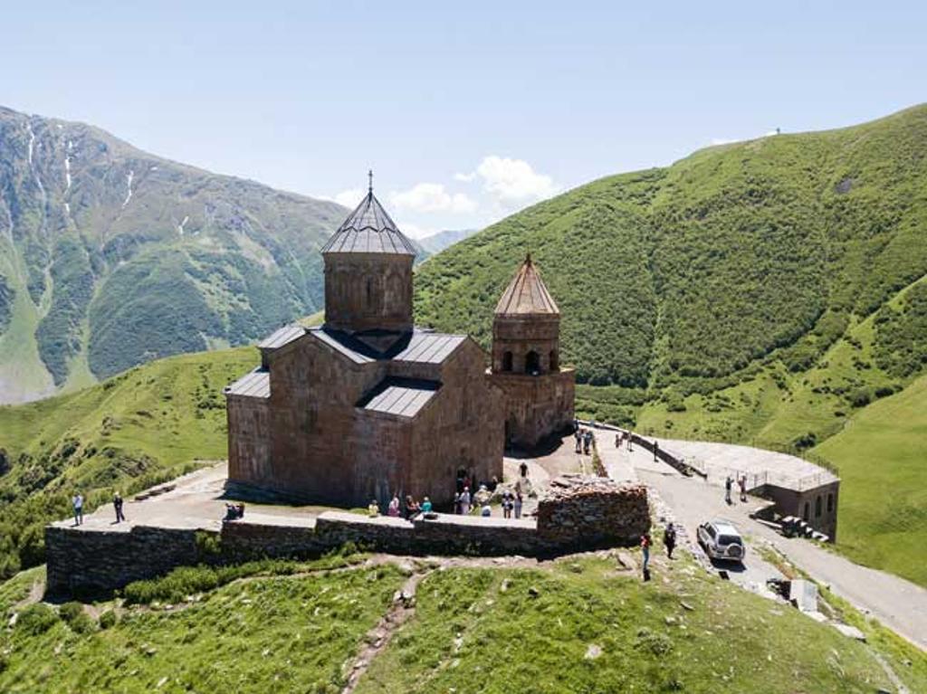 Vista de Tsminda Sameba, Iglesia de la Santísima Trinidad cerca de la aldea de Gergeti en Georgia, bajo el Monte Kazbegi 