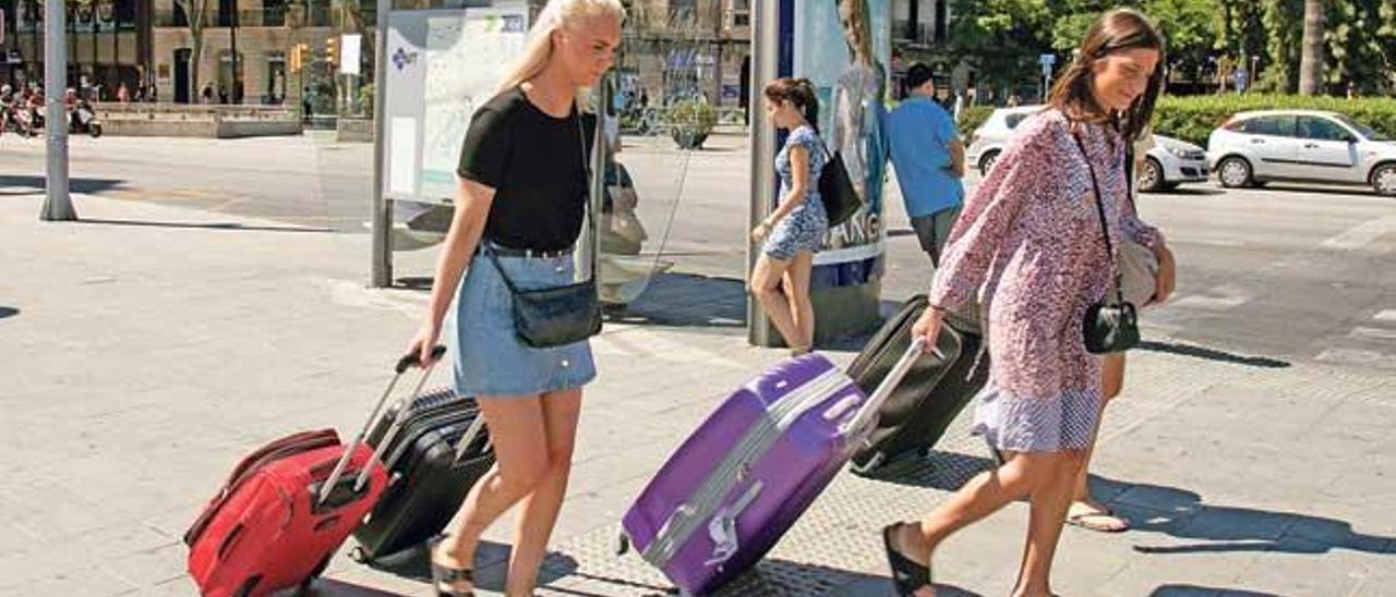 Turistas con su equipaje por el centro de Palma, en una imagen de esta semana.