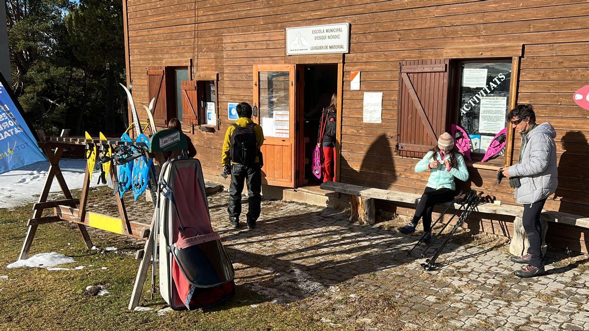 Diverses persones preparant-se per una jornada d'esquí nòrdic a la zona del lloguer de material de l'estació de Lles