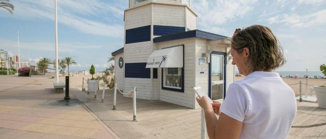 Una mujer consulta su móvil en la playa de Gandia. | ÀLEX OLTRA