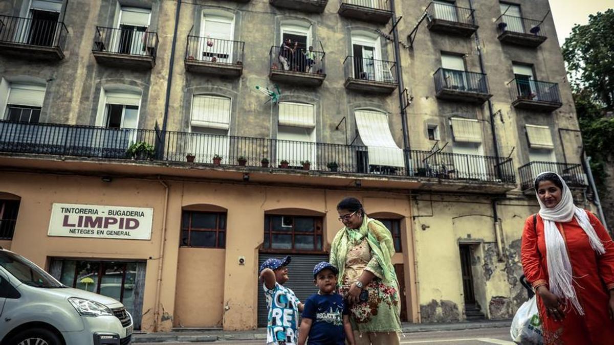 Una familia de origen inmigrante se despide en la calle de Ripoll.