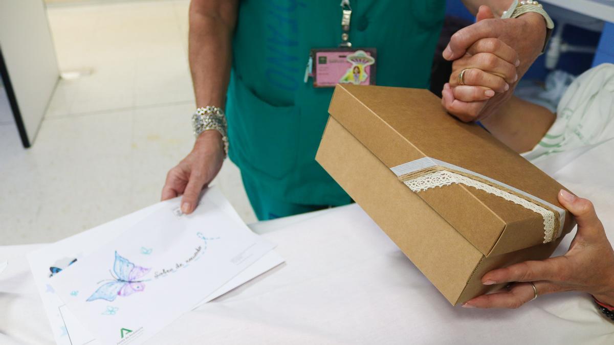 Una madre recibe la caja de recuerdo de su bebé fallecido en el Hospital Materno