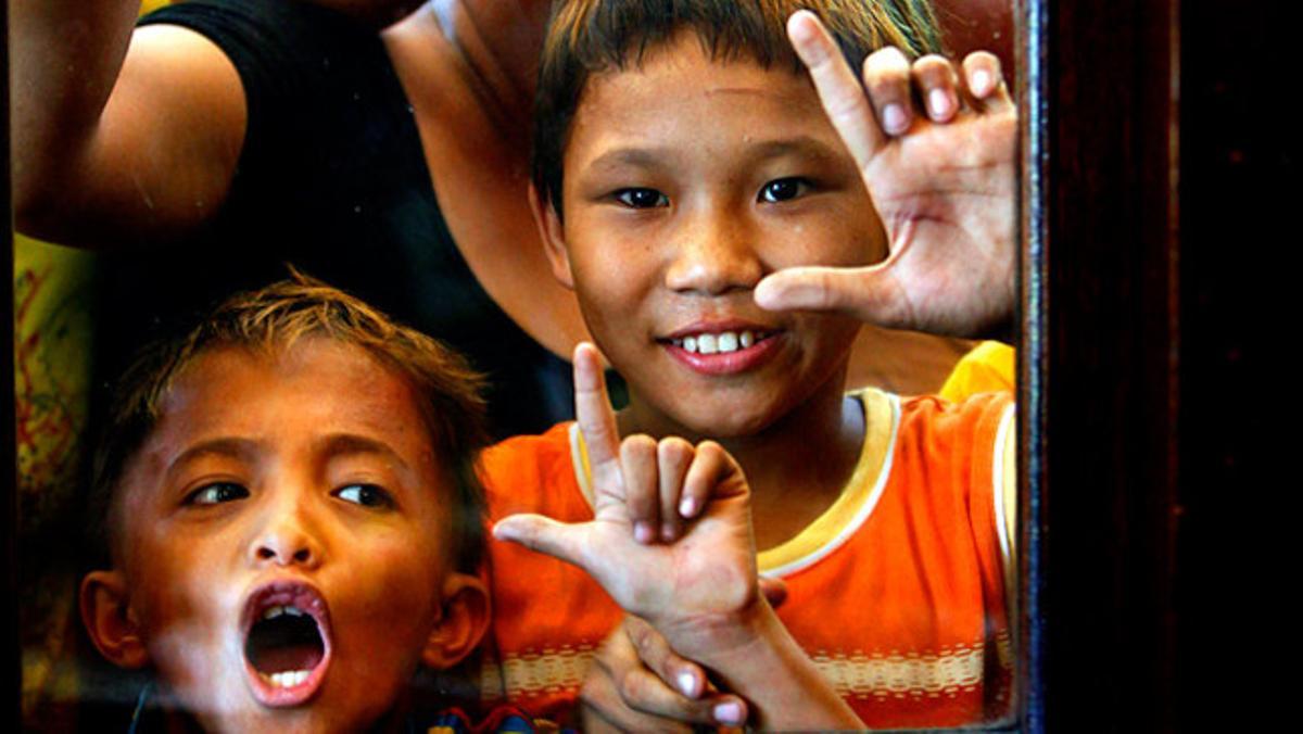 Uns nens fan el símbol de la lletra ’L¿ que significa ’Laban¿ (lluita) mentre miren per la finestra d¿un restaurant el candidat a la presidència de Filipines Benigno Aquino III.