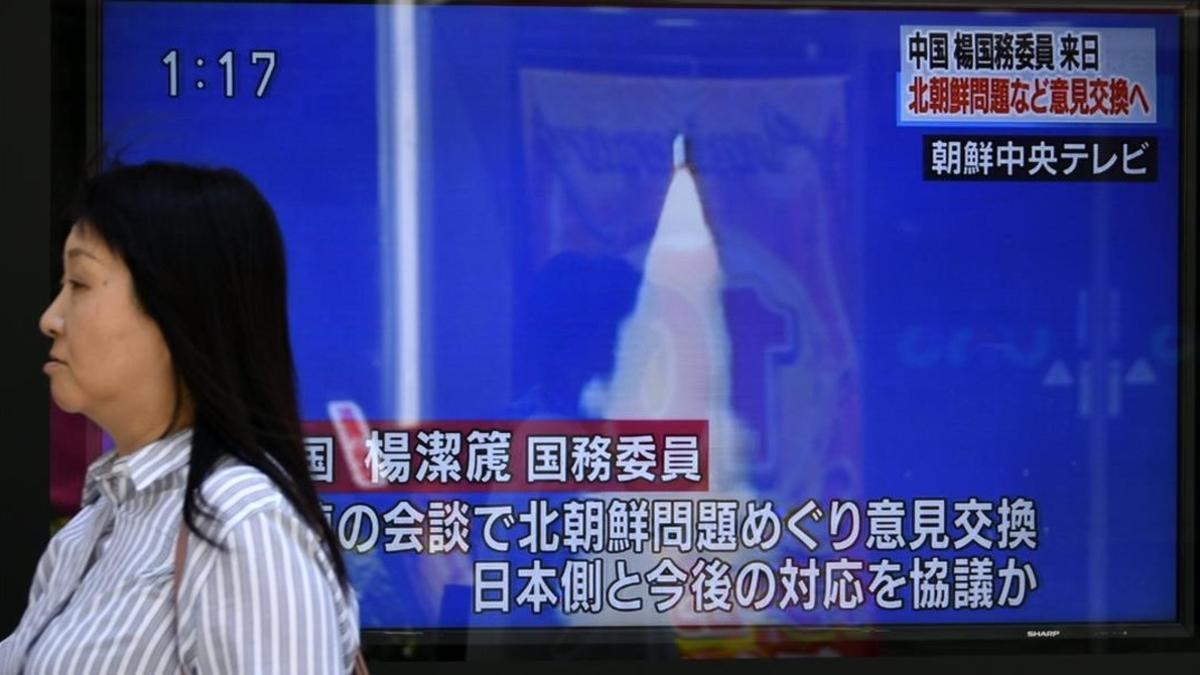 Una mujer pasa por delante de una pantalla de televisión que informa del lanzamiento de Pionyang, en Tokio (Japón), el 29 de mayo.