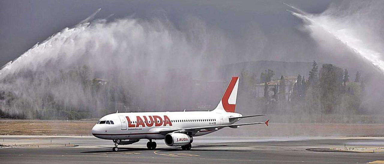 Llegada del Airbus de Lauda a Son Sant Joan recibido por los chorros de agua de los bomberos.