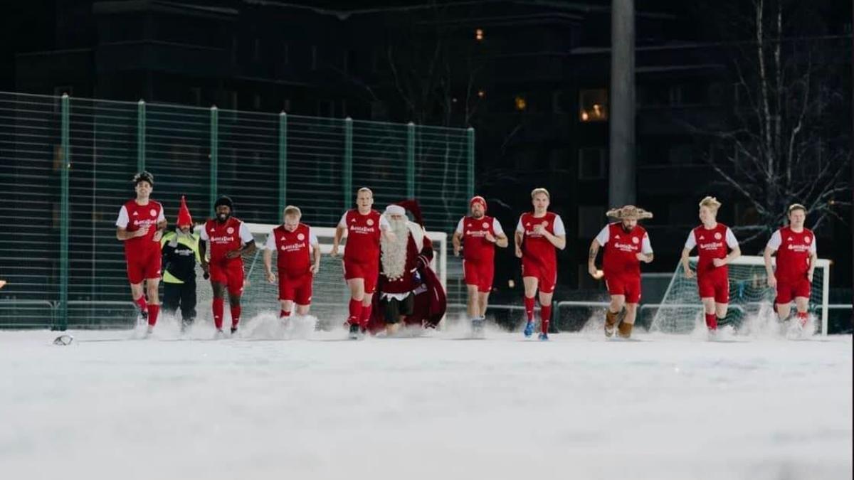 Los jugadores del FC Santa Claus con Papá Noel, su presidente honorífico, en un campo nevado.