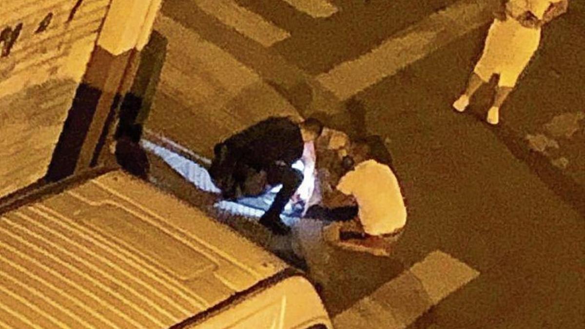 La Policía y un vecino atienden a la víctima tras el suceso.