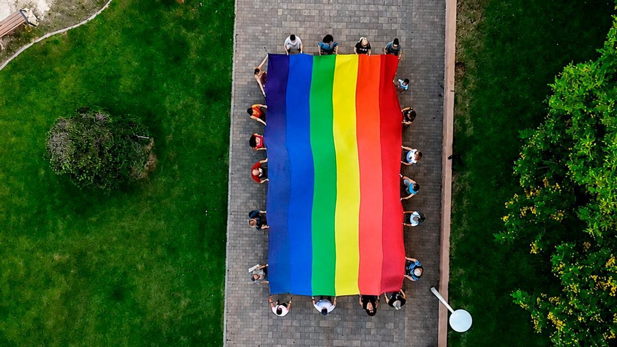 Bandera gigante con los colores del arco iris.