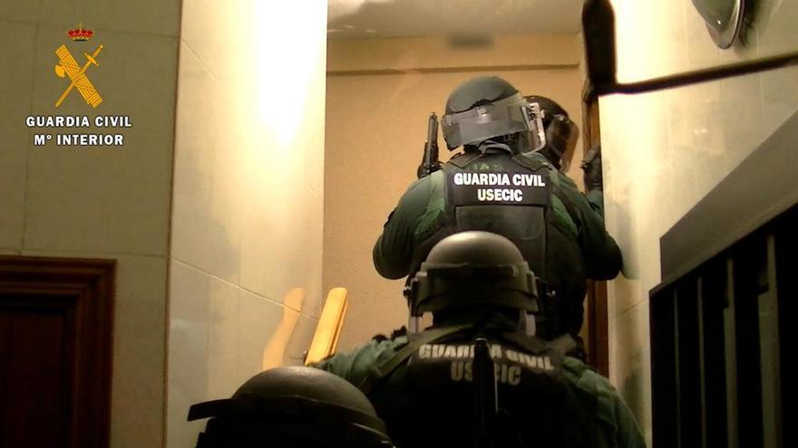 Agentes de la Guardia Civil entran a uno de los pisos con mujeres sometidas