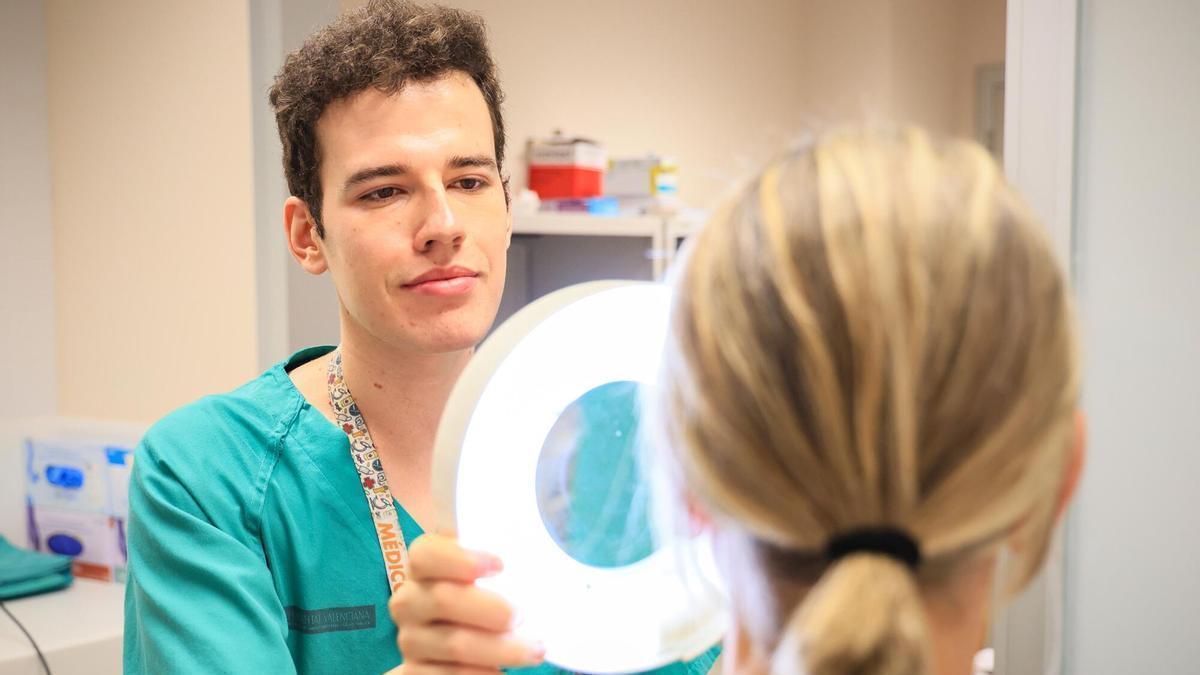 El residente en Dermatología de La Fe, Miguel Lasheras, analiza la piel de una paciente. SANIDAD . HOSPITAL LA FE . DERMATÓLOGO