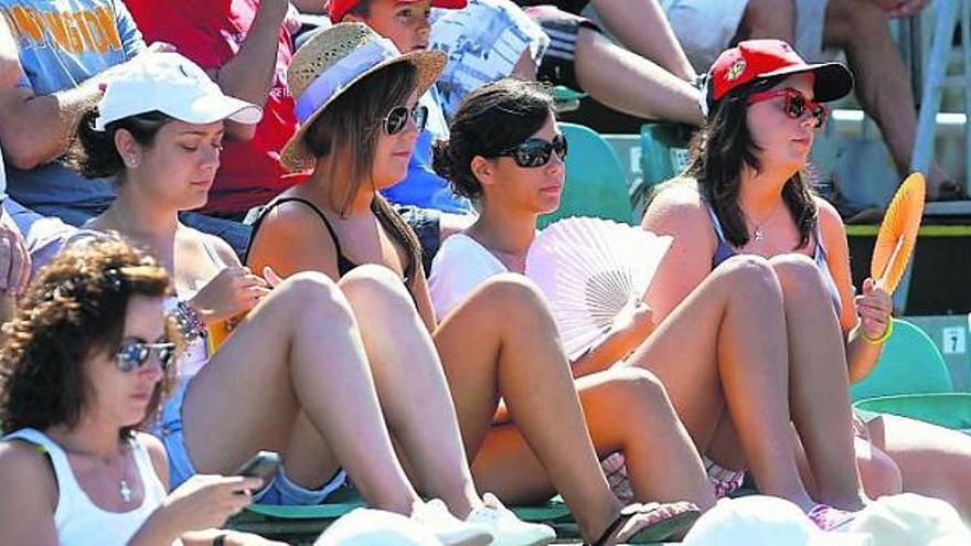 Un grupo de aficionadas con sombreros, gorras y abanicos. / mara villamuza