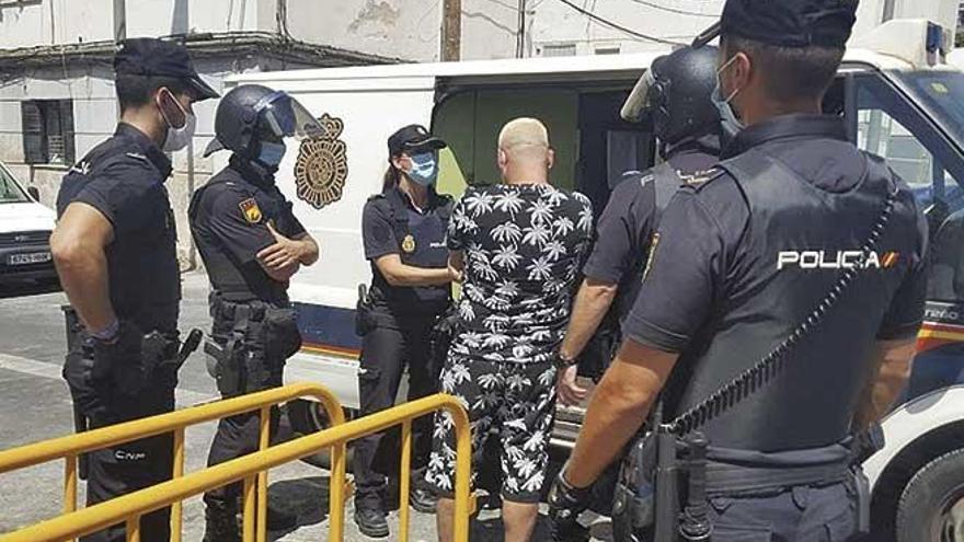 Agentes de la Policía Nacional introducen en el furgón a un detenido el jueves en la redada de Camp Redó.