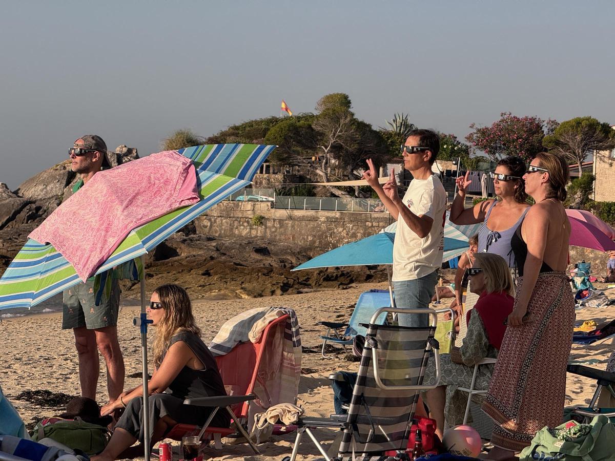 Bañistas y vecinos siguen el eclipse solar desde Loureiro. Bañistas y vecinos siguen el eclipse solar desde Loureiro.