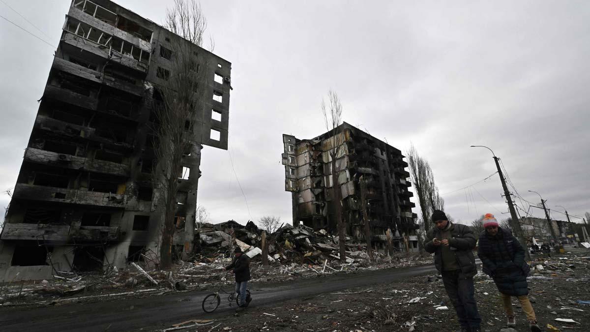 Civiles pasan junto a edificios destruidos en Borodianka.