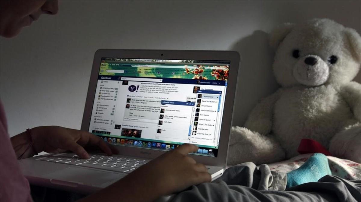 Un niño navega por internet en su habitación.